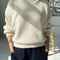 model wearing cream cotton sweater with thick banded bottom and mockneck