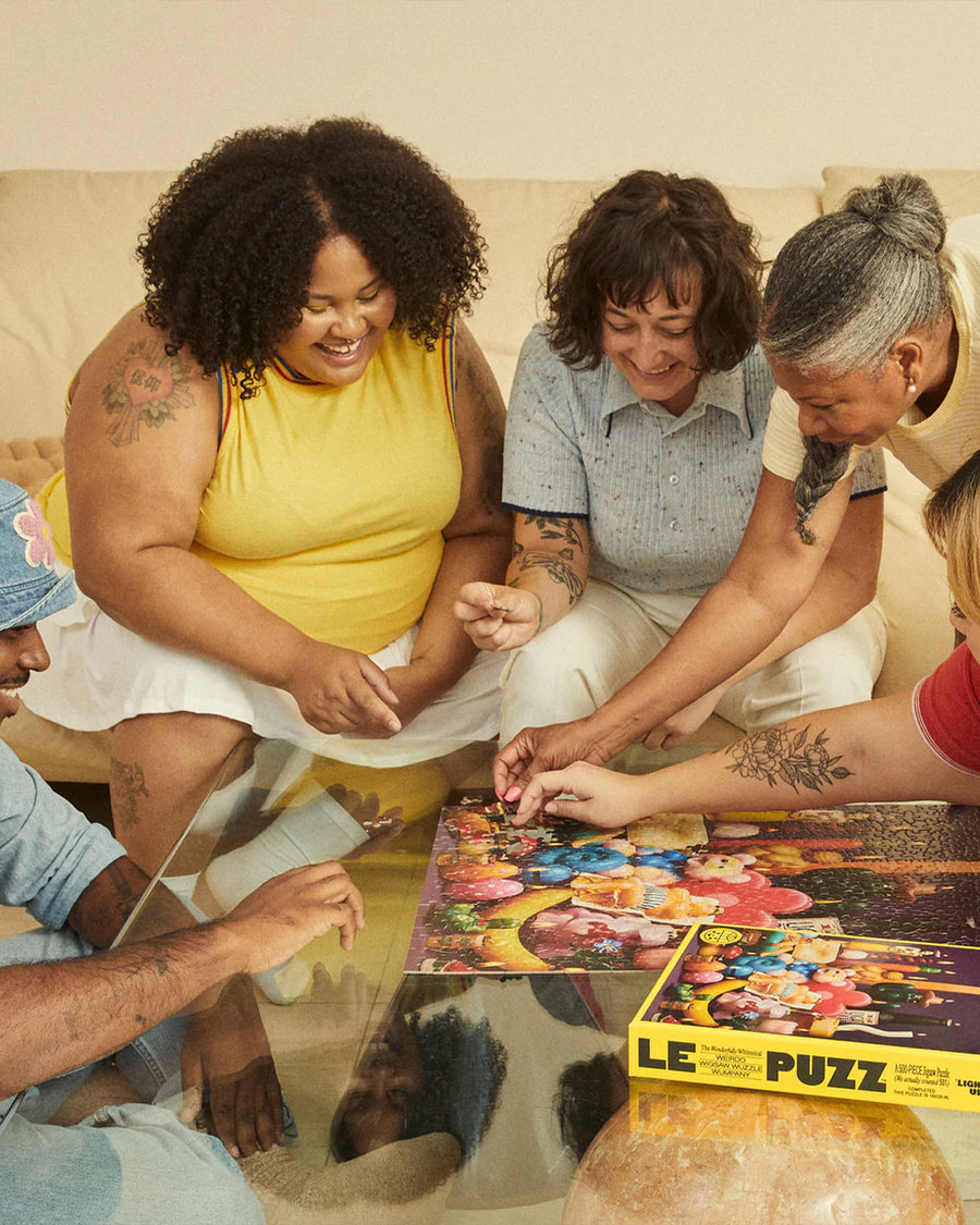 models putting together le puzz 500 piece puzzle with various novelty lit candles