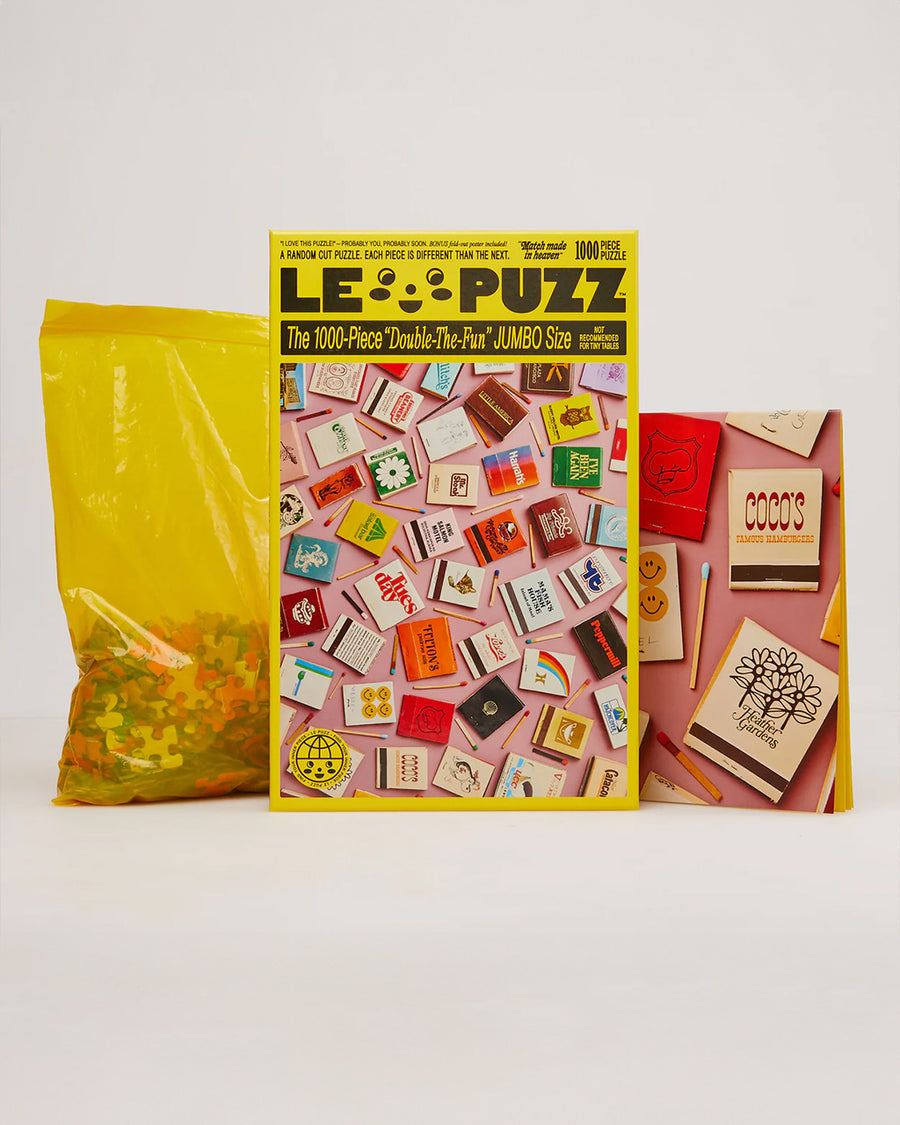 le puzz 1000 piece puzzle with pink ground and cute and colorful matchbooks, posters and bagged pieces