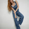 model wearing medium denim overalls with front pocket and lee tag