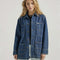 model wearing medium denim chore coat with four front patch pockets and button front