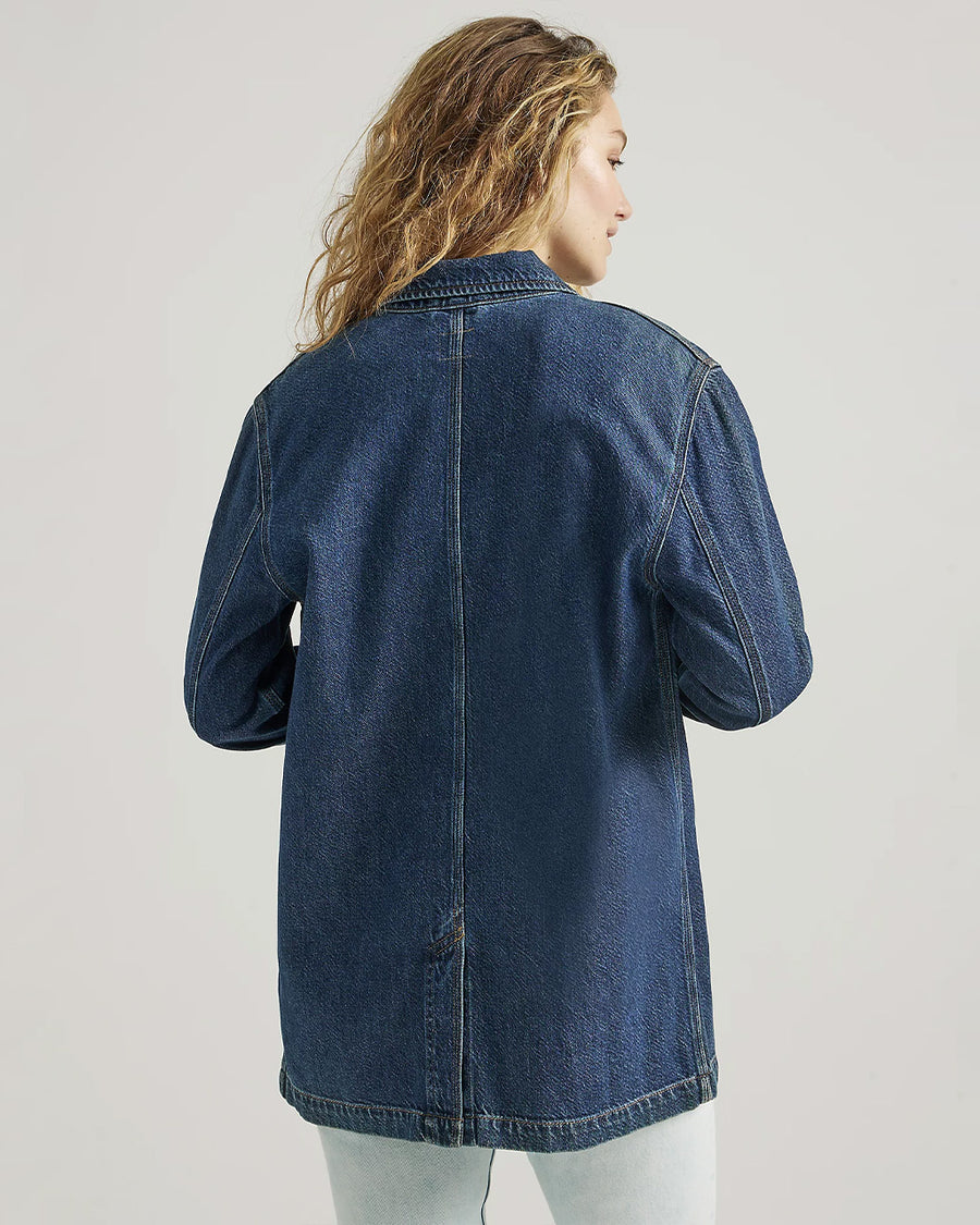 back view of model wearing medium denim chore coat with four front patch pockets and button front