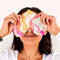 model holding colorful swirl heart shaped eye pillow over their eyes