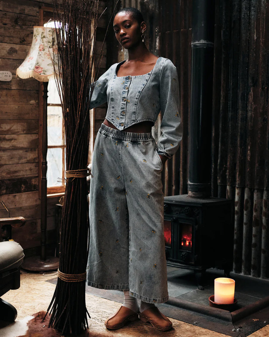 model wearing washed wide leg denim with dainty yellow embroidered floral print with matching top