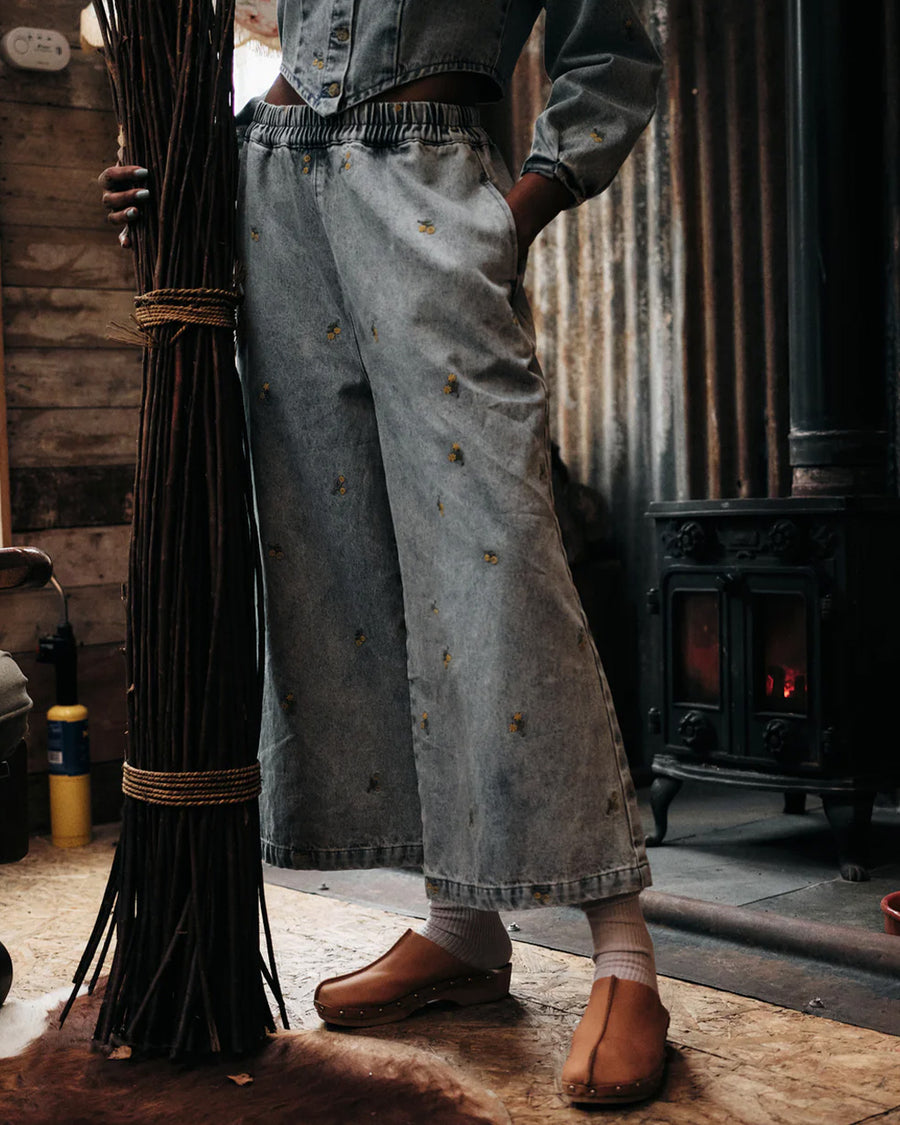 model wearing washed wide leg denim with dainty yellow embroidered floral print