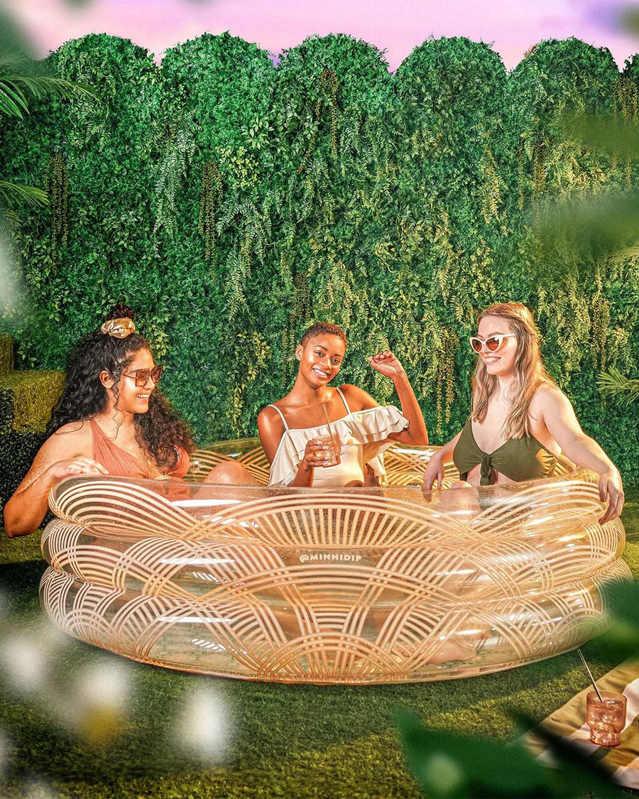 models relaxing in clear inflatable pool with rattan colored lines and scalloped top