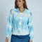 model wearing blue and white knit cardigan with crochet white flower button front and wide lapel collar