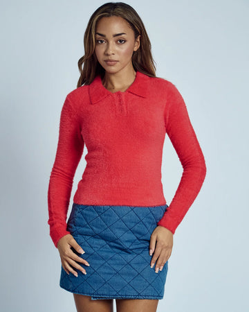 model wearing red fuzzy textured long sleeve polo neck top