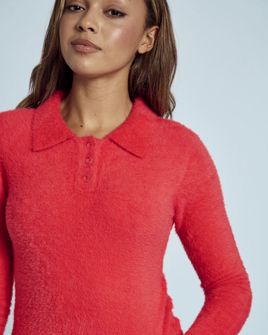 up close of model wearing red fuzzy textured long sleeve polo neck top