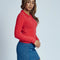 side view of model wearing red fuzzy textured long sleeve polo neck top