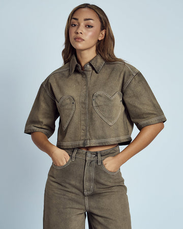 model wearing cropped chocolate acid wash button down top with heart shaped front pockets