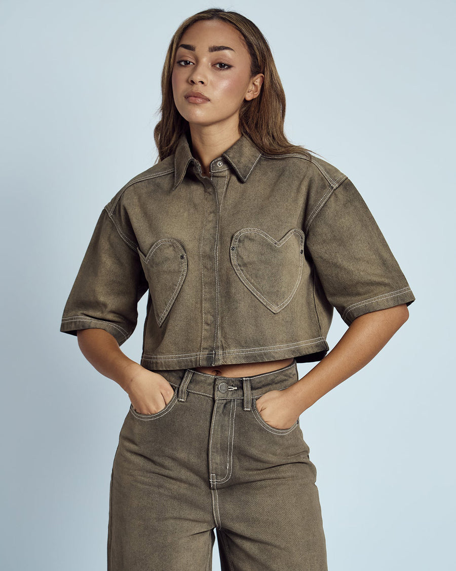 model wearing cropped chocolate acid wash button down top with heart shaped front pockets