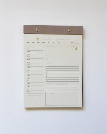 brown and tan daily planner notepad with gold accents