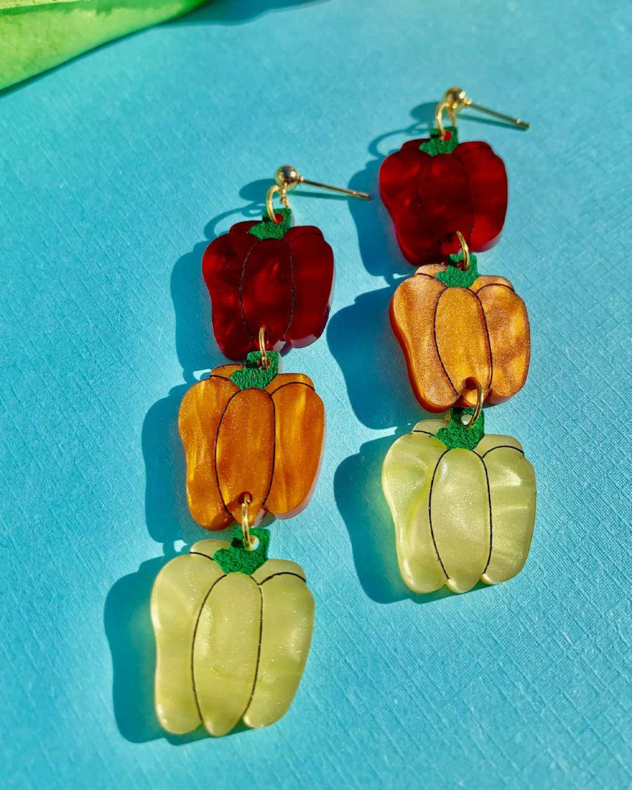 up close of pair of bell pepper earrings in red, orange and yellow tiered