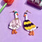 pair of two mismatched duck earrings: goose in a flower costume and goose in a bee costume