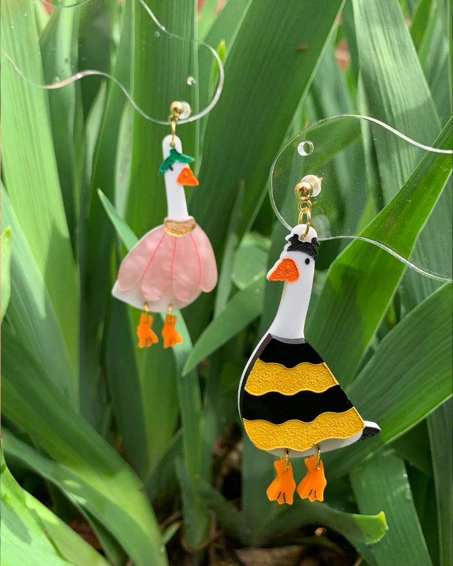 hanging pair of two mismatched duck earrings: goose in a flower costume and goose in a bee costume