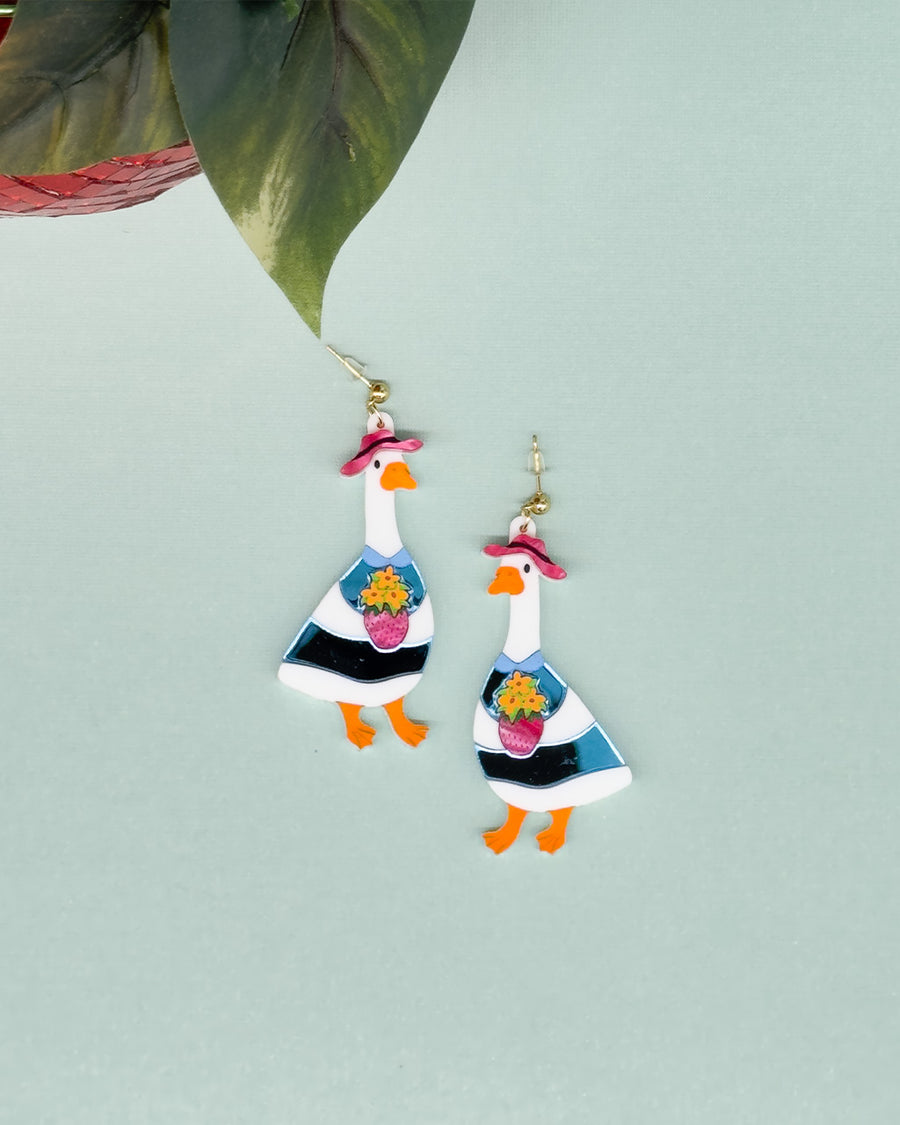 dangle earrings with a goose in a pink hat holding a bouquet of flowers in the ban.do strawberry vase