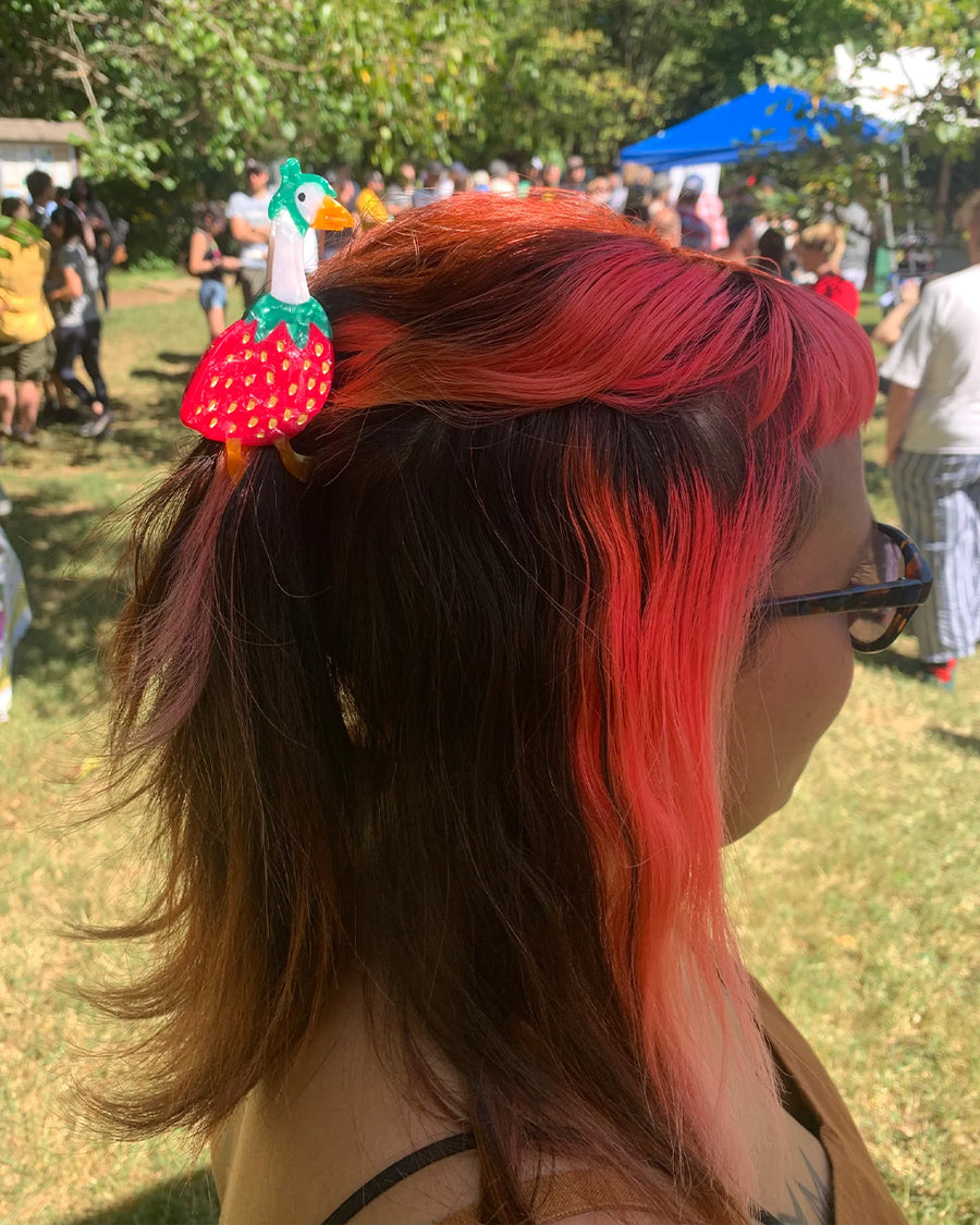 model wearing hair claw with goose wearing a strawberry outfit in their hair