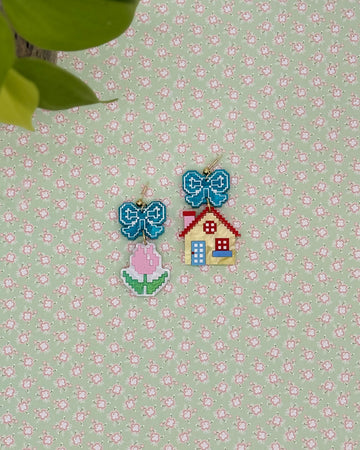 earrings with blue bow studs and pink tulip dangle and yellow house dangle