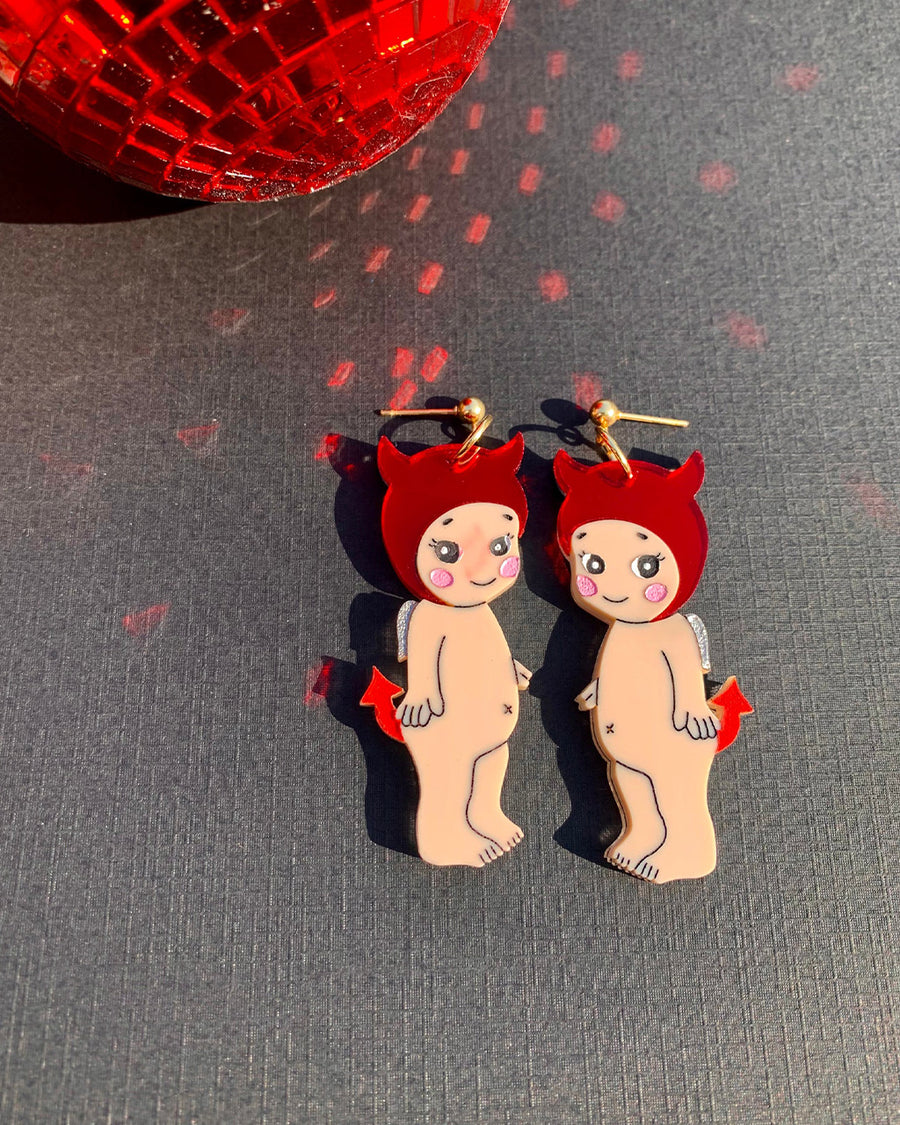 baby wearing devil horn hat and tail dangle earrings