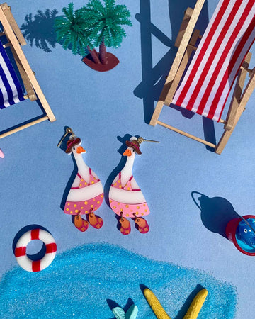 earrings with geese dressed in pink bathing suits in a beach setting