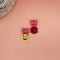 earrings with pink bow stud and one earring with a yellow smiley dangle and a pink dice dangle