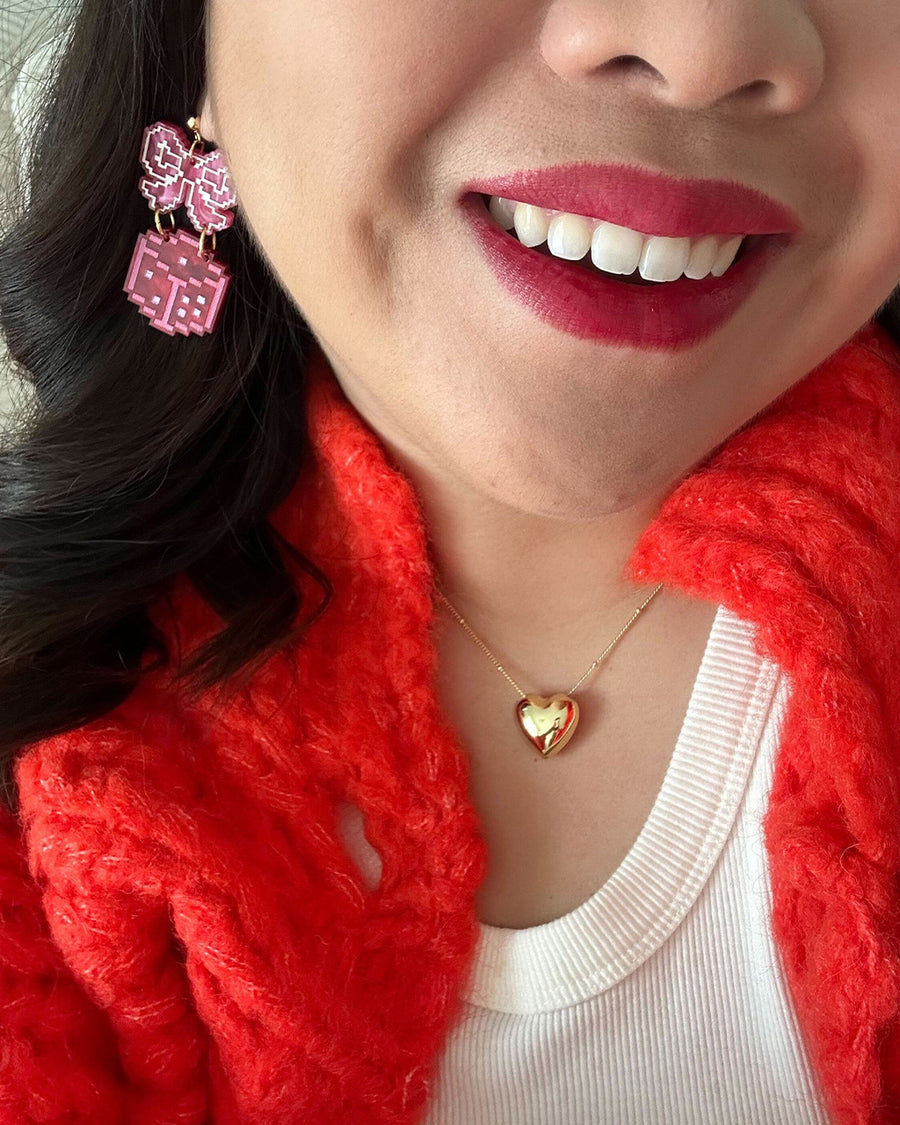 model wearing pink bow dangle earrings with pink dice