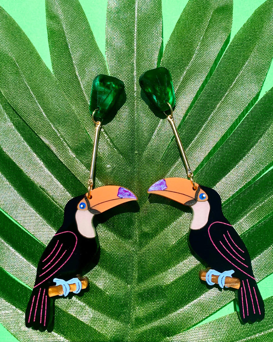 toucan shaped dangle earrings with green leaf stud