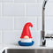 gnome dish brush with red hat and blue tray on a sink