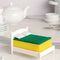 white mini bed frame with green and yellow kitchen sponge on it on a table