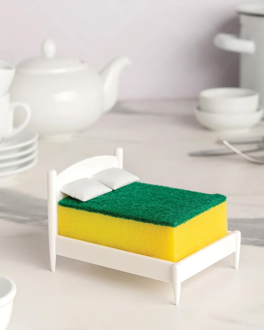 white mini bed frame with green and yellow kitchen sponge on it on a table