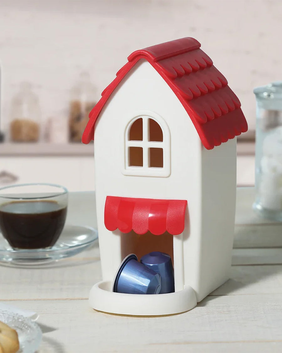 red and white plastic 'coffee shop' coffee capsule holder on a counter