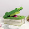 green crocodile shaped veggie chopper with an onion in it