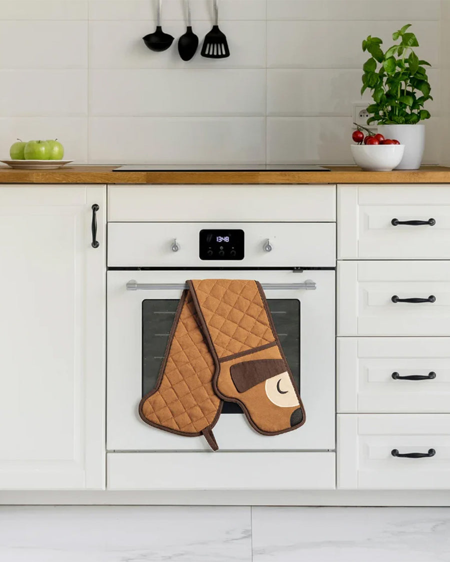 long brown dog oven mitt hanging on oven handle