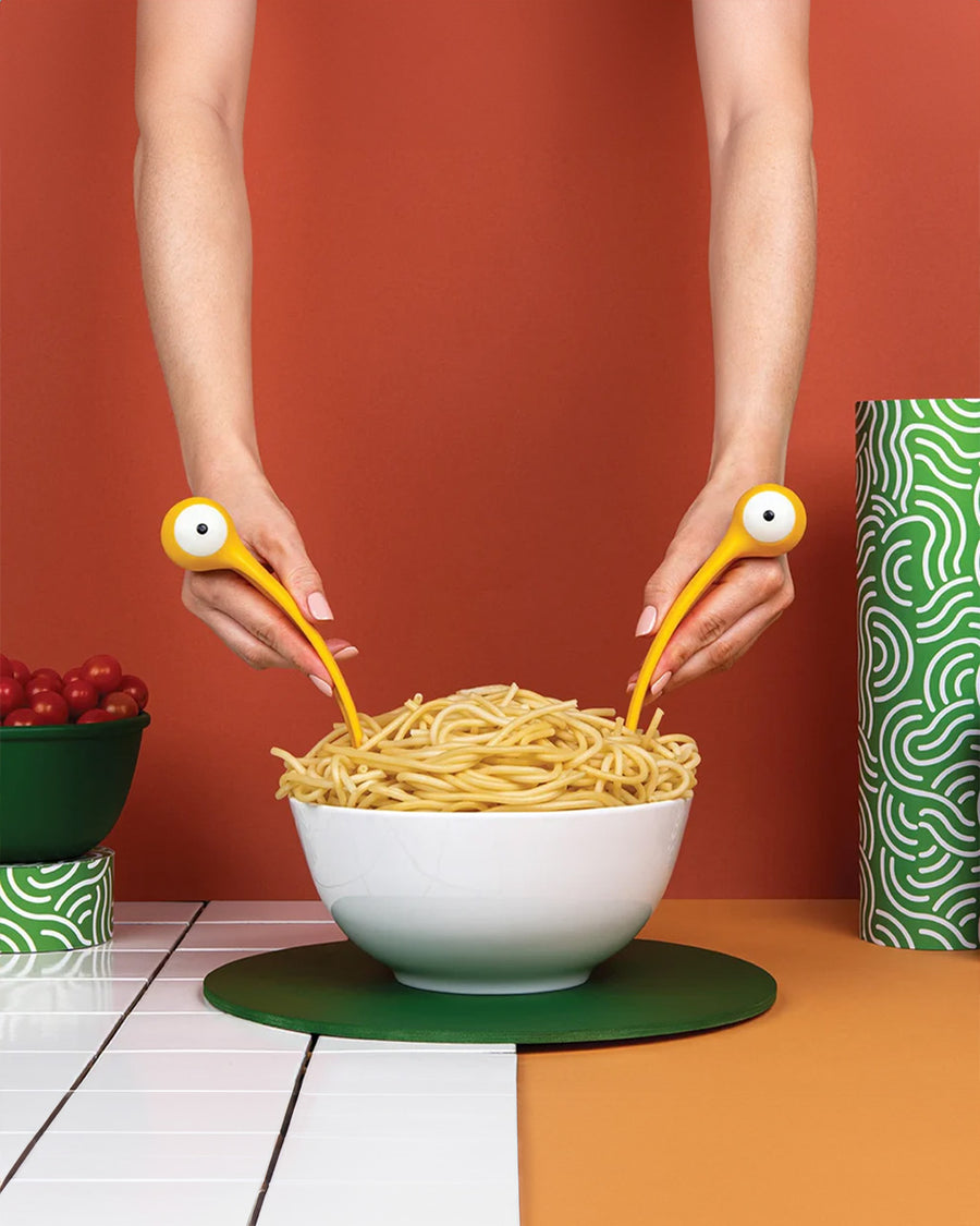 model using yellow monster pasta server utensils