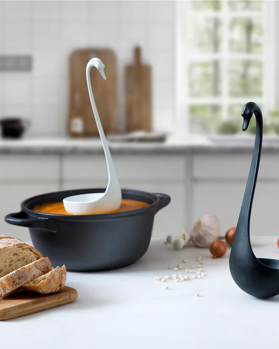 white swan floating ladle in a black pot