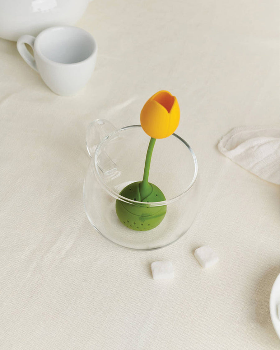 top view of yellow tulip infuser in a clear cup