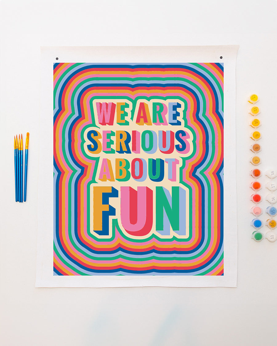 colorful paint by numbers kit with 'we are serious about fun' typography and comes with pots of paint and paintbrushes