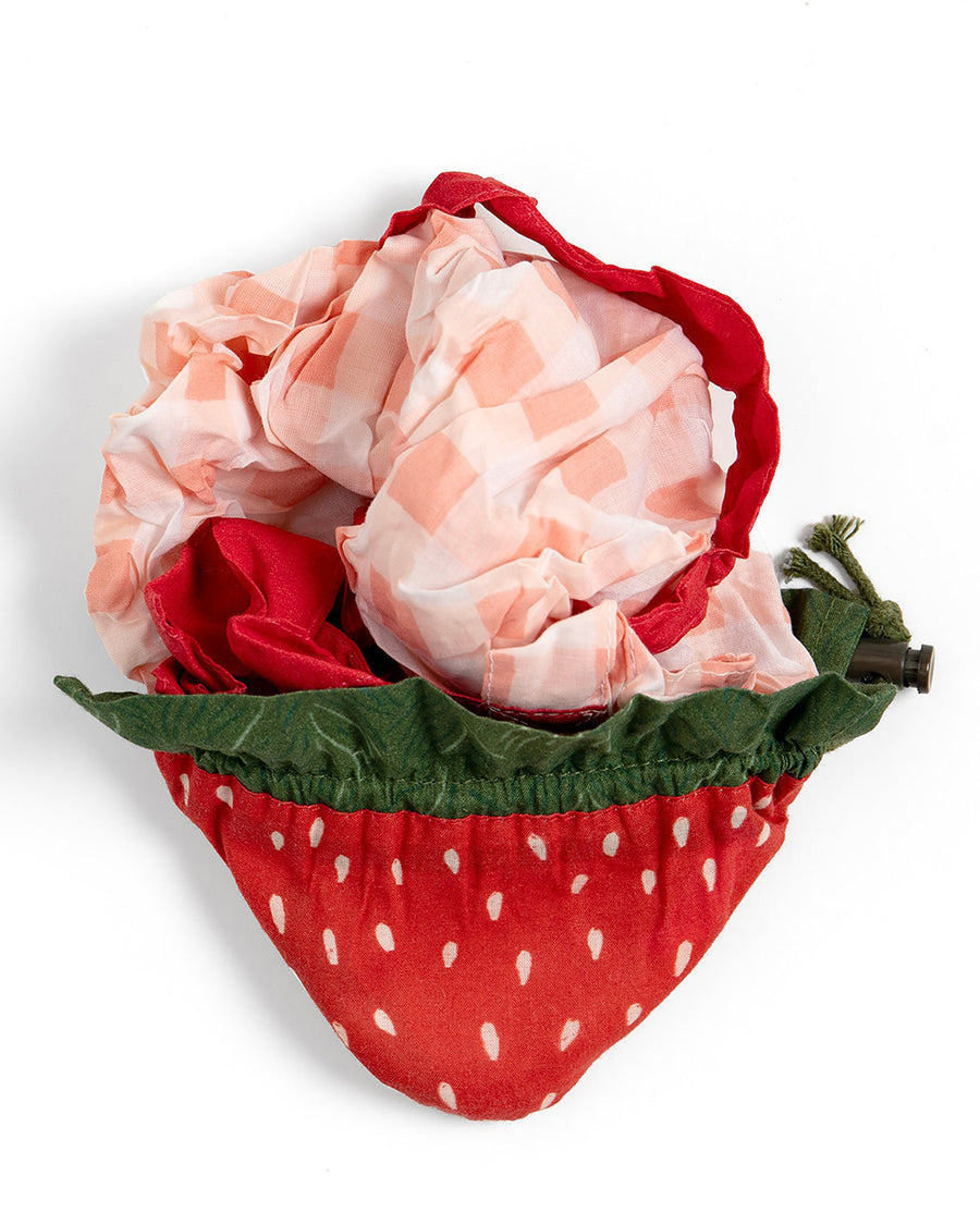 packed red gingham market bag with red strap and strawberry bag peeking out
