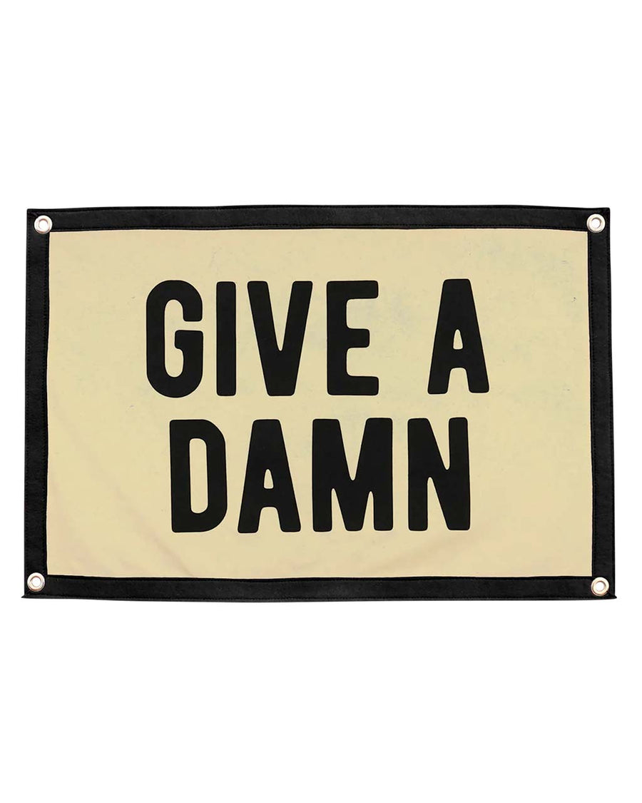 cream camp flag with black border and black 'give a damn' across the front