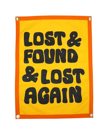 yellow wool flag with orange banner and black 'lost & found & lost again'