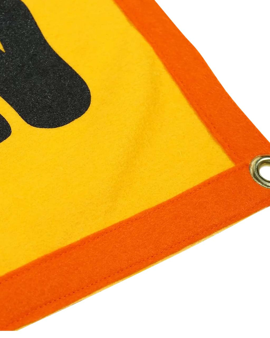 up close of yellow wool flag with orange banner and black 'lost & found & lost again'