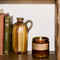 teakwood and tobacco large concentrated candle on a shelf with decor