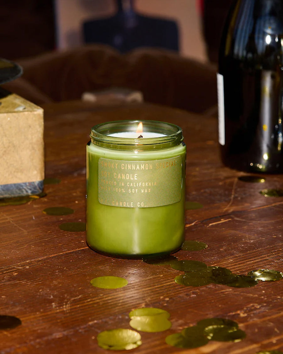 smoky cinnamon special soy standard candle on a table surrounded by confetti