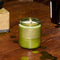 spruce scented soy standard candle on a table surrounded by gold confetti