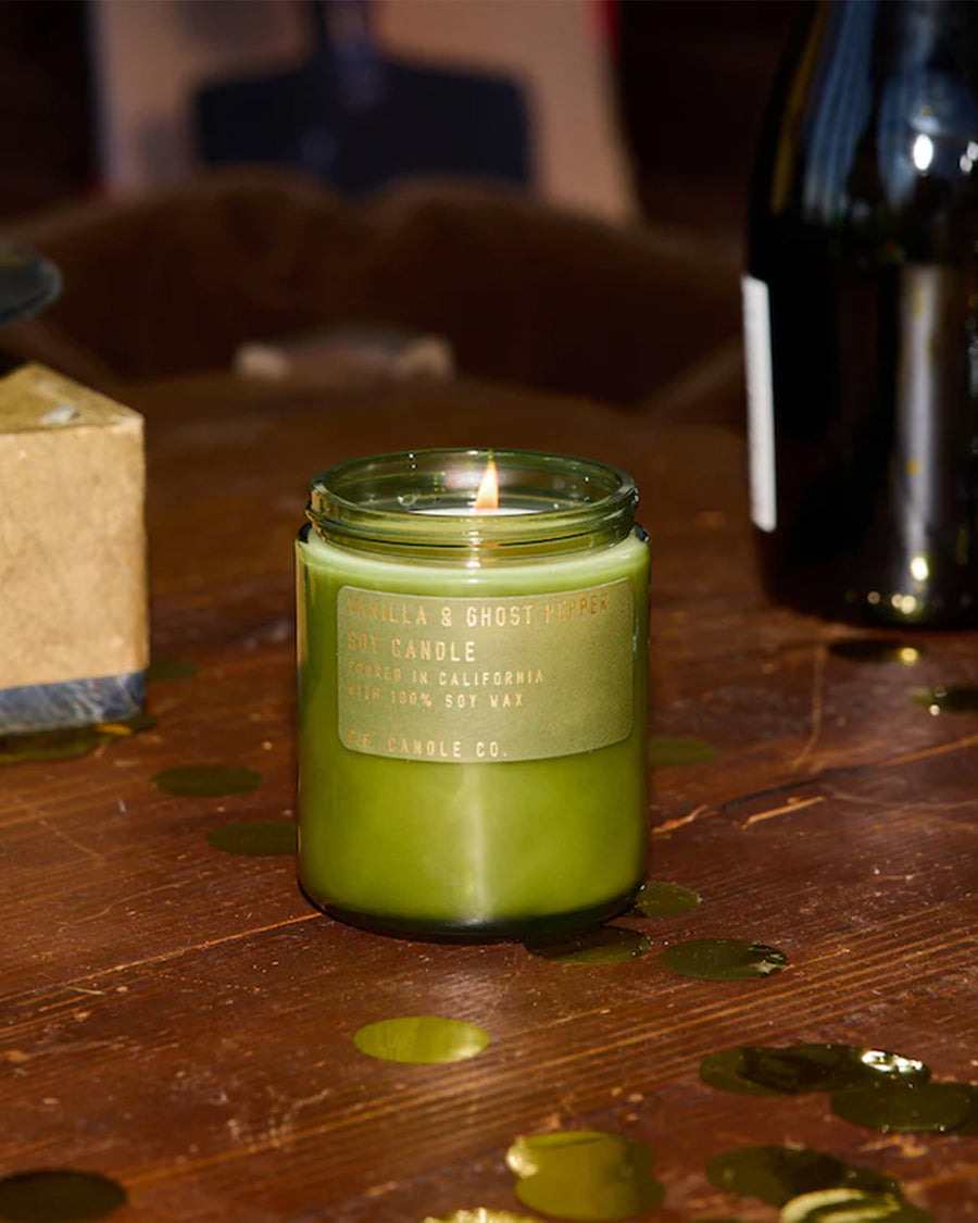 vanilla and ghost pepper scented candle on table surrounded by gold confetti