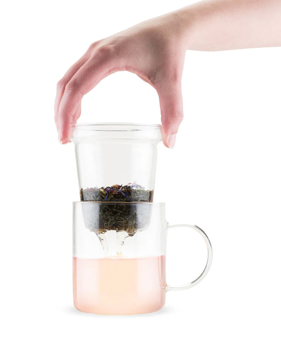 model pulling infuser out of 12 oz clear glass tea glass with removable infuser