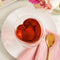 heart shaped clear glass mug with red tea inside on a table display