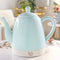 mint ceramic electric tea kettle with rose gold accents on a table