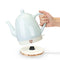 model lifting mint ceramic electric tea kettle off of rose gold base